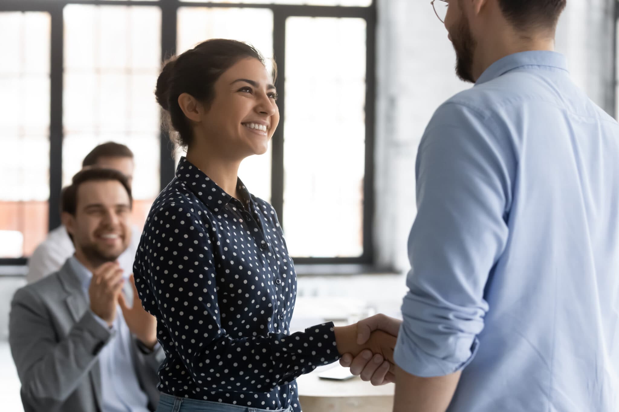 Smiling woman in polka dot dress in business meeting